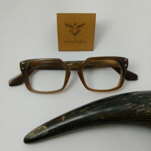 brown eyeglasses kept near buffalo horn