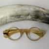 horn rimmed round eyeglasses kept aside of horn
